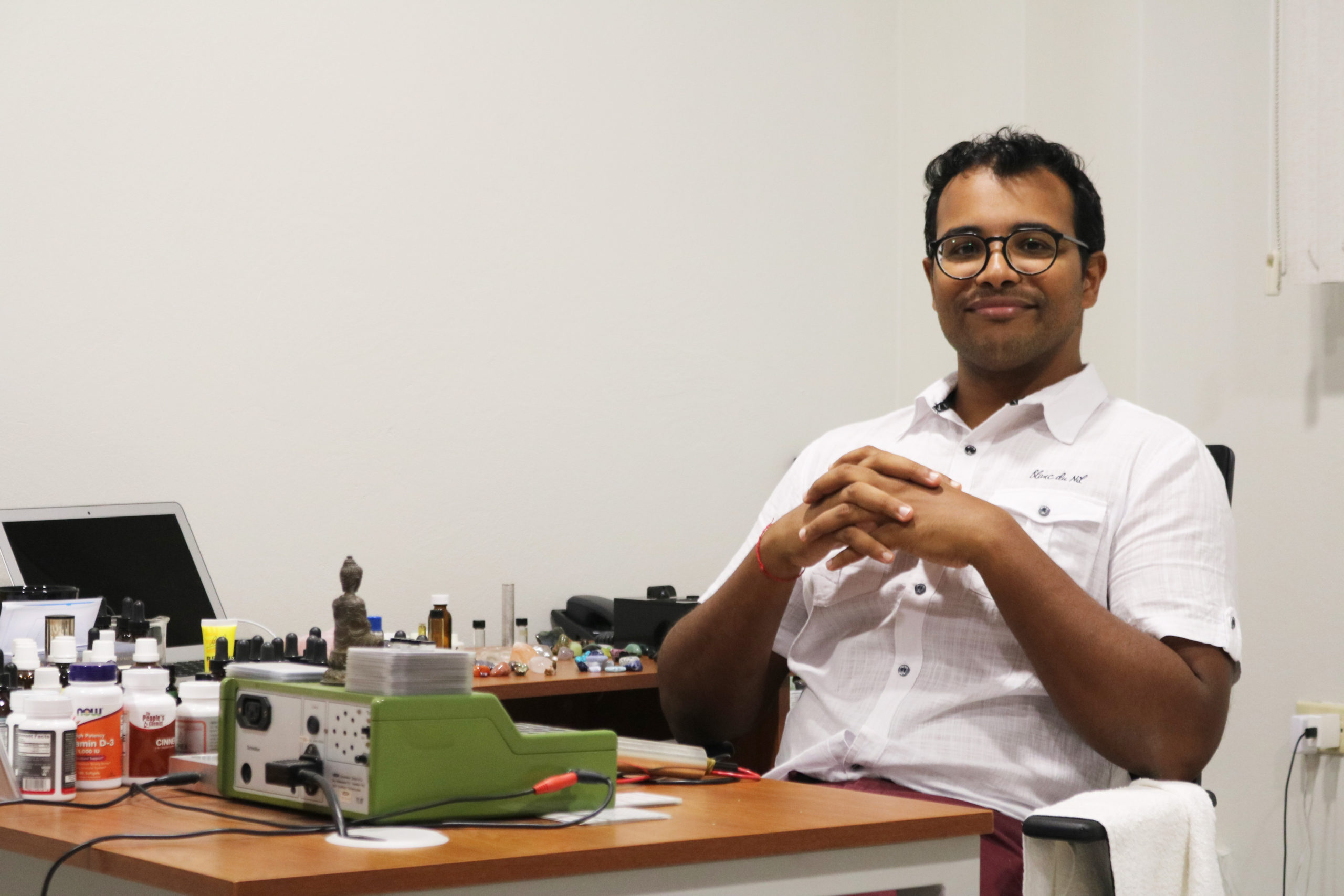 Dr. Adriel Ramnarine sitting at a desk. 